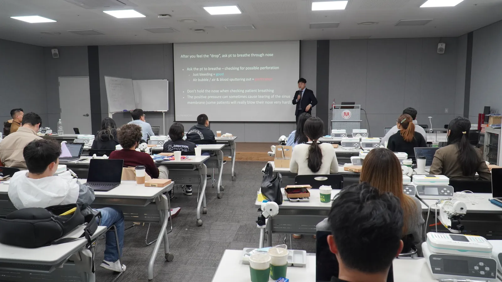 Dr. Kwon lecturing on implant surgery to a room of dentists
