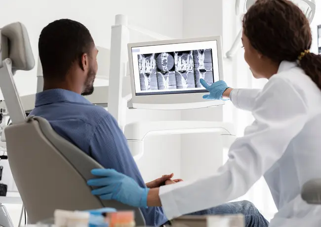 a dentist is showing a patient an x-ray of his teeth