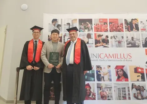 three men in graduation gowns stand in front of a sign that says unicamillus