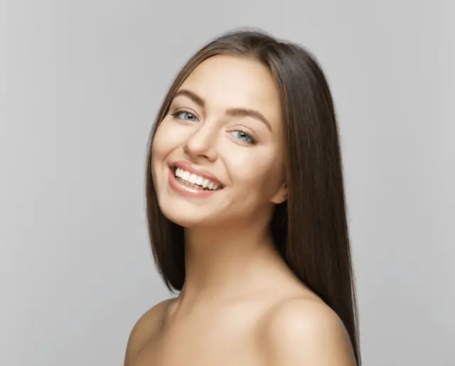 a woman with long hair is smiling for the camera